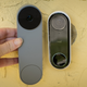 A photo of a hand holding the new Nest Doorbell next to the old one
